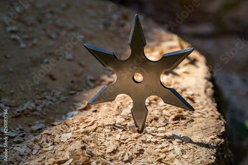 Shuriken (throwing star), traditional japanese ninja cold weapon stuck in wooden background