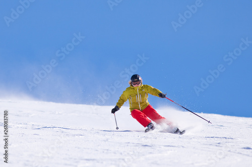 Young woman downhill skiing on an open slope at a ski resort in the Canadian Rocky Mountains, Alberta, Canada