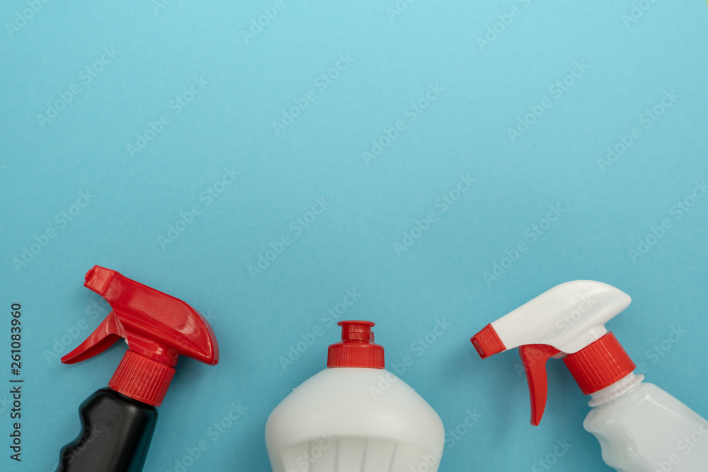 Tops of white and black plastic bottles of different detergents on blue background. Spring house cleaning Tops of white and black plastic bottles of different detergents on blue background. Spring house cleaning