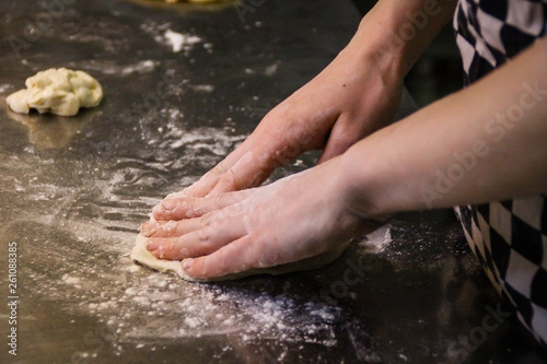 Girl chef kneading dough for eclairs. Plum, butter and flour.
