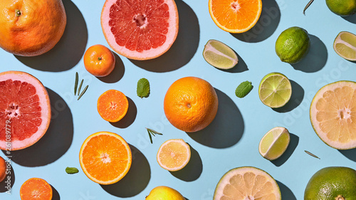 Fresh sliced citrus fruits pattern on blue background.
