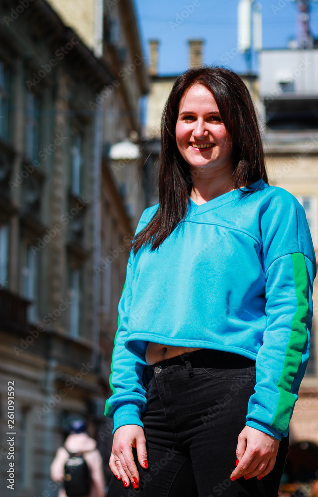 Livestyle portrait of a brunette girl in a blue dwarf toe on the streets of the city of Lvov.Ukraine Livestyle portrait of a brunette girl in a blue dwarf toe on the streets of the city of Lvov.Ukraine