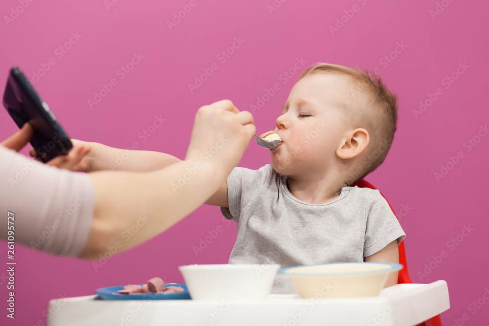 Little boy does not want to eat Mashed potatoes. Child eats breakfast at home, while watching cartoon on tablet Little boy does not want to eat Mashed potatoes. Child eats breakfast at home, while watching cartoon on tablet