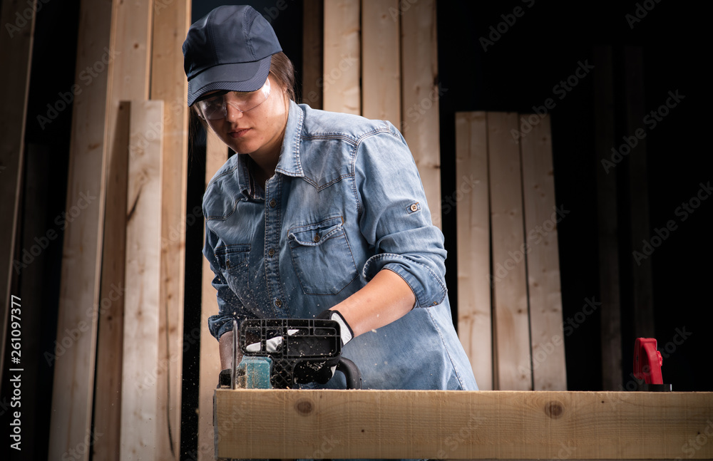 Young woman using modern electric saw in the workshop Young woman using modern electric saw in the workshop