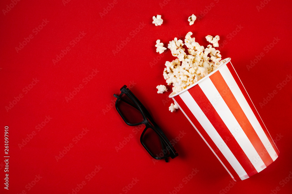 Movie night concept - pop corn, glasses, bright red background