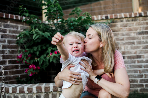 loving mother kisses her toddler during a temper tantrum photo