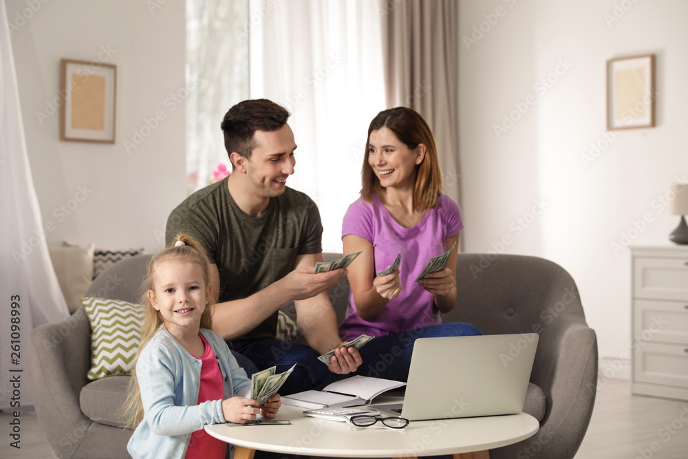 Happy family counting money on sofa at home Happy family counting money on sofa at home