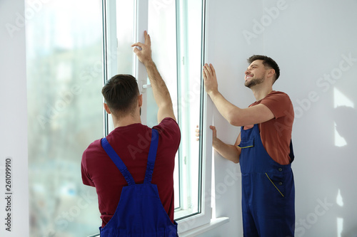 Εκτύπωση καμβά Construction workers installing plastic window in house