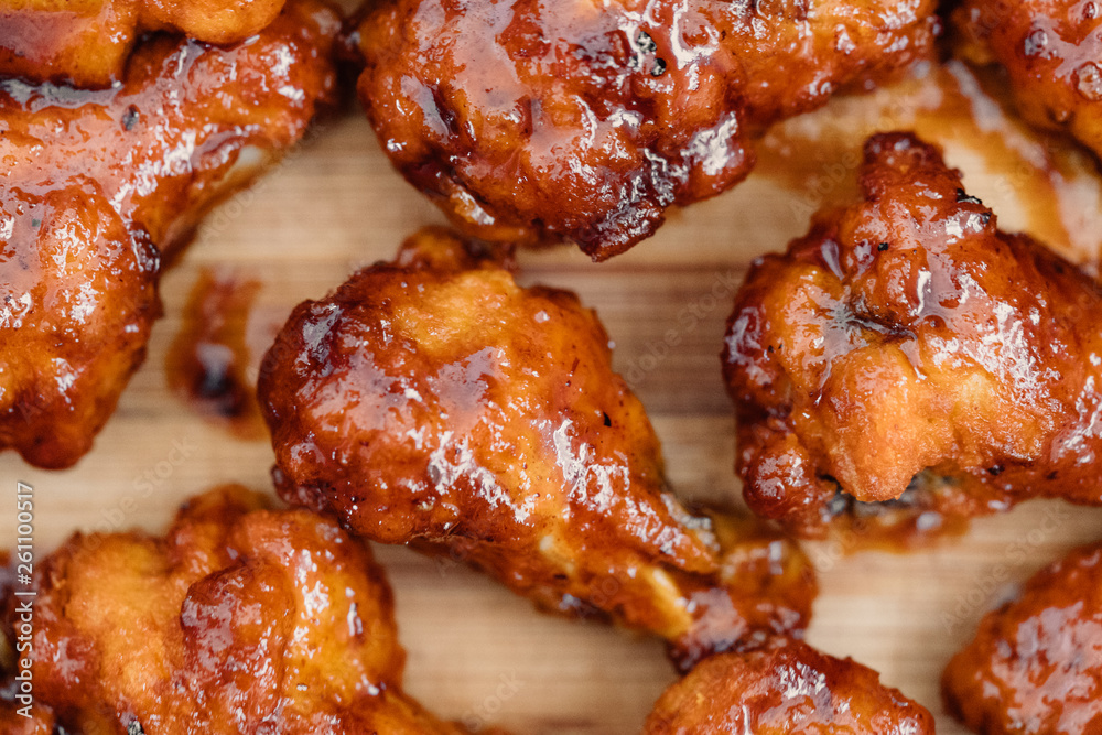 Crispy barbecue chicken wings covered in a sweet and tangy bbq sauce and served at a cookout. Crispy barbecue chicken wings covered in a sweet and tangy bbq sauce and served at a cookout.