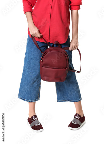 Woman in stylish shoes holding backpack isolated on white