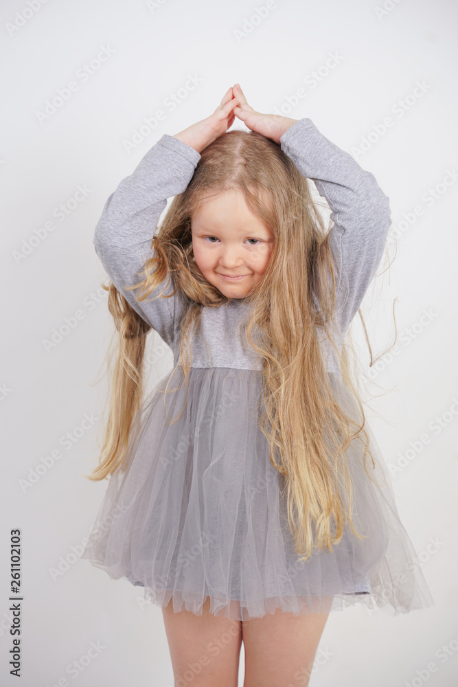 cute orphan girl stands and holds her hands over her head in the form of a house, dreaming of an apartment, on a white background in the Studio cute orphan girl stands and holds her hands over her head in the form of a house, dreaming of an apartment, on a white background in the Studio