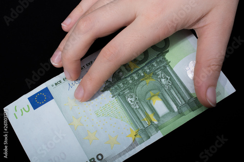 Hand holding 100 euro banknote on a black background photo