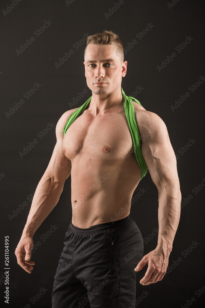 handsome man with muscles on a black background handsome man with muscles on a black background