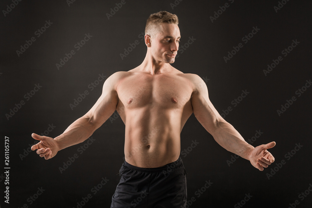 handsome man with muscles on a black background handsome man with muscles on a black background