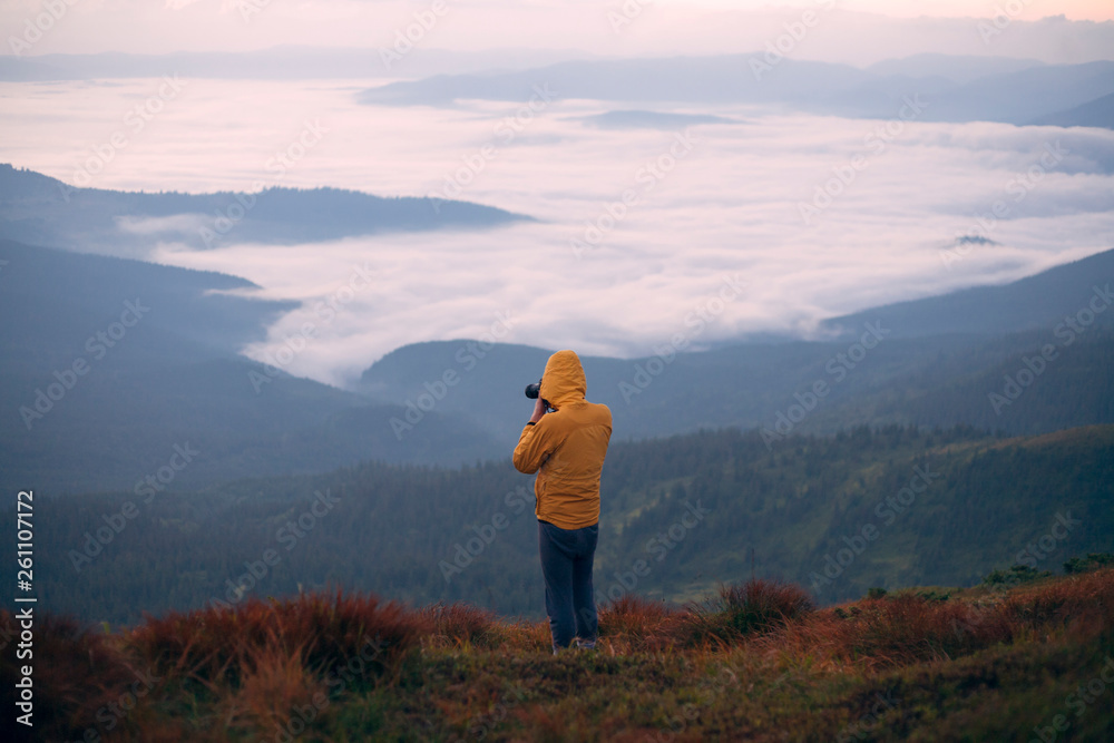 Man in yellow jacket taking photographs in the Carpathian Mountain Range Man in yellow jacket taking photographs in the Carpathian Mountain Range