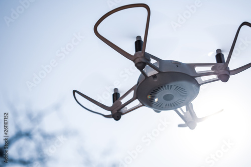Fototapeta Naklejka Na Ścianę i Meble -  Quadcopter drone hovering in a bright blue sky