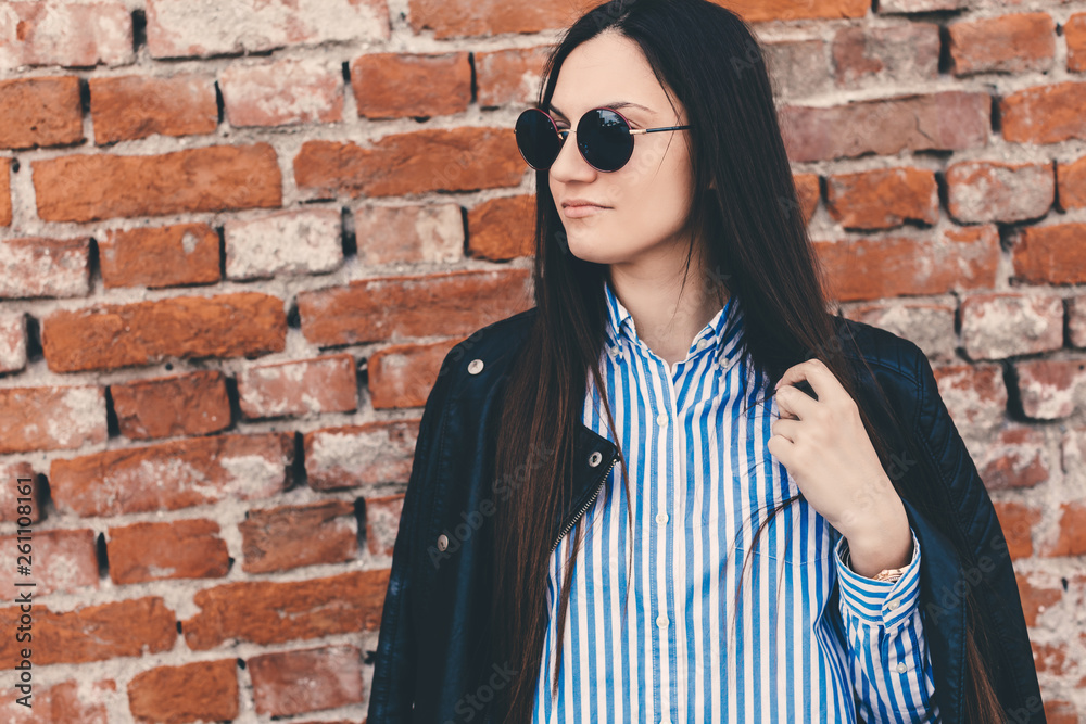 Young modern urban woman in front of brick wall Young modern urban woman in front of brick wall