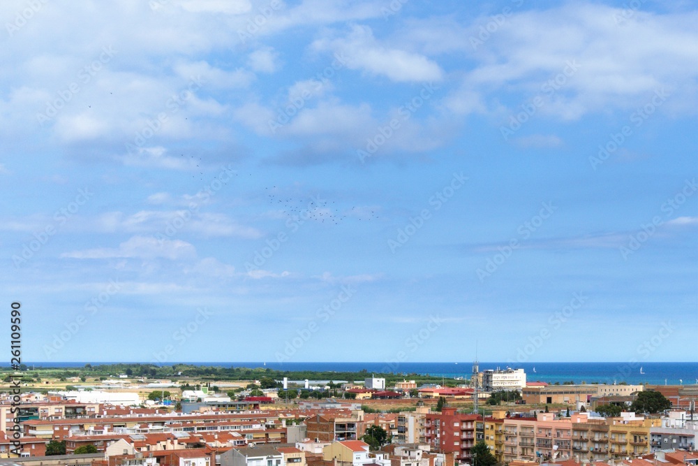 White clouds and blue sky over the Spanish seaside town.