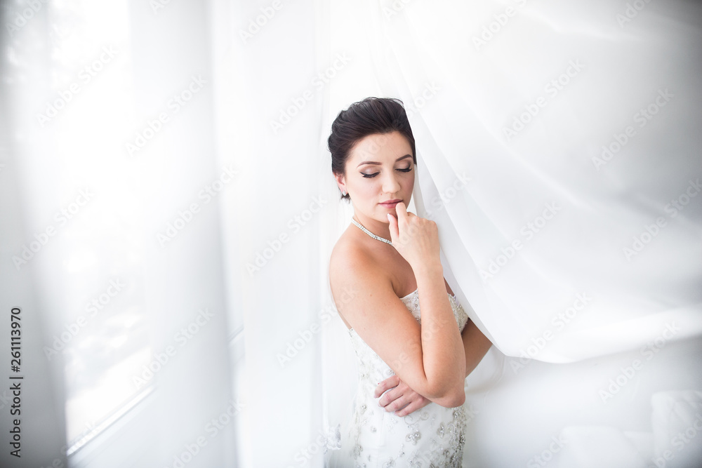 Beautiful sexy bride in white dress posing under curtain Beautiful sexy bride in white dress posing under curtain