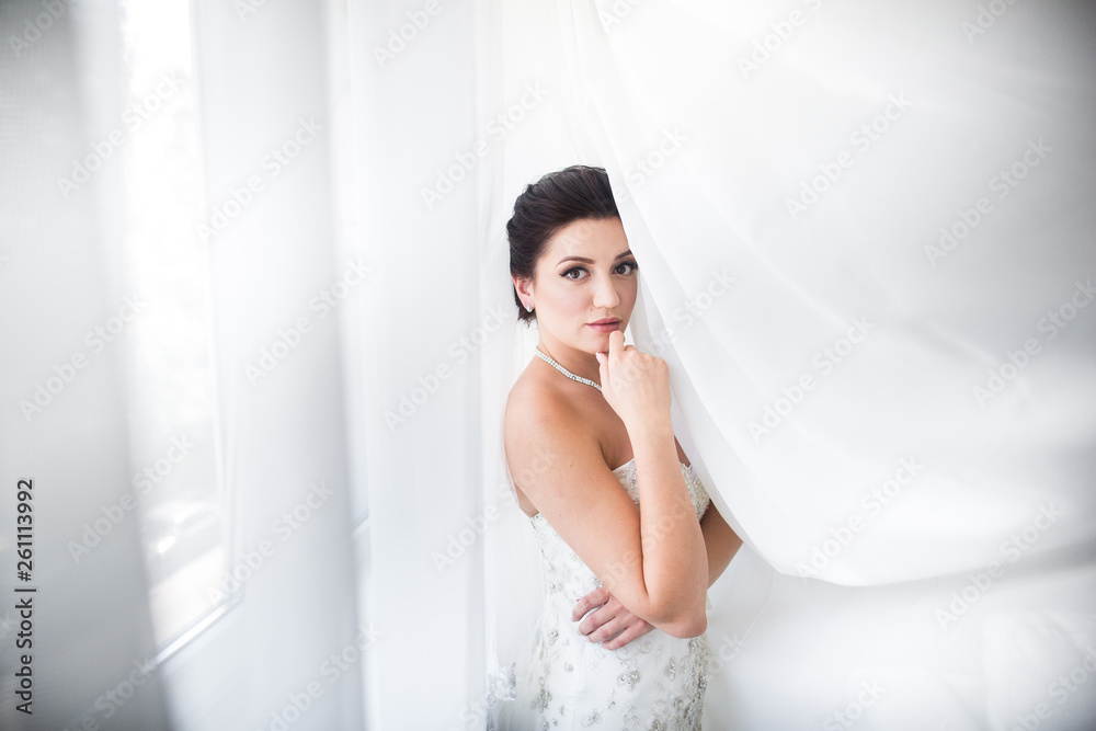 Beautiful sexy bride in white dress posing under curtain Beautiful sexy bride in white dress posing under curtain