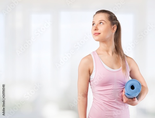 Close-up attractive young woman holding dumbbell on blurred background