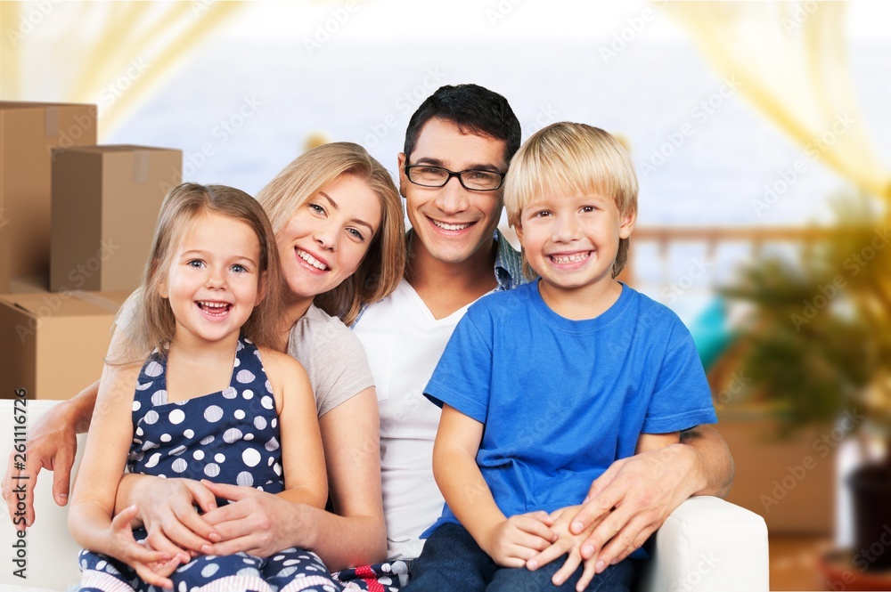 Beautiful smiling family sitting at sofa at home Beautiful smiling family sitting at sofa at home
