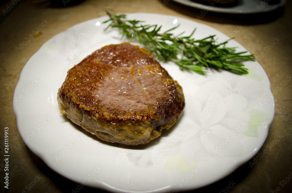 Roasted beef steak on the plate with green rosemary Roasted beef steak on the plate with green rosemary