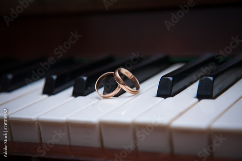 two gold wedding rings on the piano keys