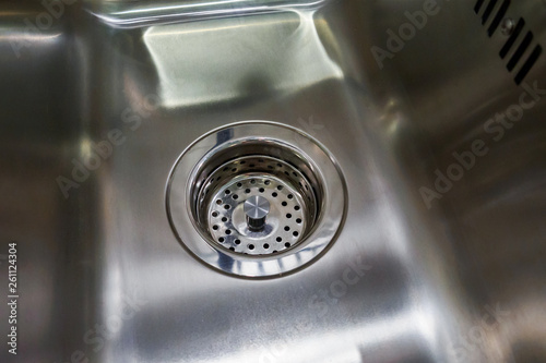 empty and dry metal kitchen sink with grill on drain