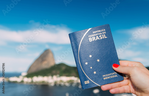 Hand holding Brazilian passport with SugarLoaf Mountain in Rio de Janeiro, Brazil in background photo