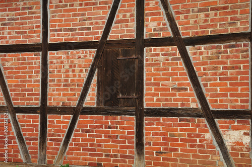 closed window in brick facade of an old barn
