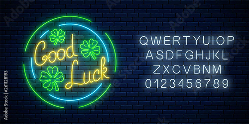 Glowing neon sign with geed luck wish and four-leaf clovers in circle frames with alphabet. Three leaves of shamrock.
