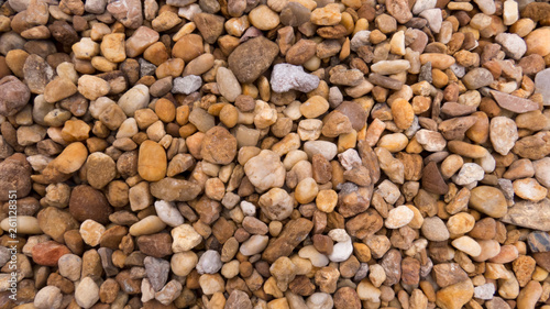 Background  lot of small pebbles of different shapes with many hue of brown.