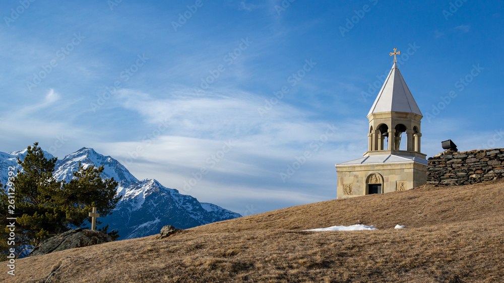 Winter landscape in Kazbegi: scenery georgian mountains and St Ilya Orthodox Church(Ioane Natlismcemeli) on the hill in Stepantsminda, Geirgia
