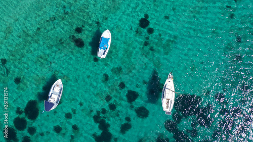 Aerial drone bird's eye view photo of traditional docked fishing boats near Naousa in island of Paros with deep emerald sea, Cyclades, Greece