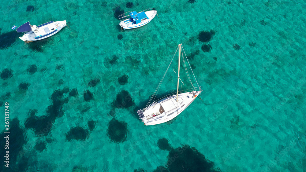Aerial drone bird's eye view photo of sail boats docked in tropical caribbean paradise bay and turquoise clear sea