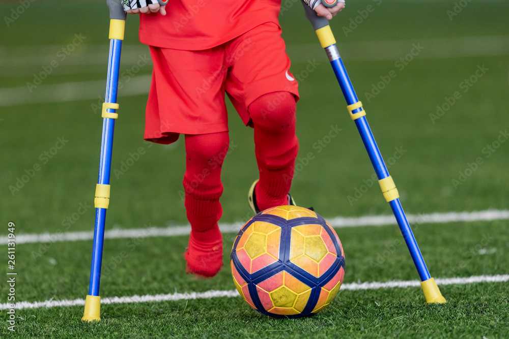 Legs of disabled football plaer with ball and crutches. Stock Photo ...