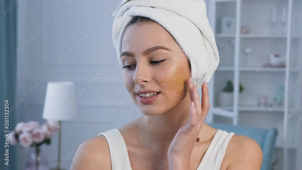 Portrait shot of beautiful young woman with towel on head applying concealer. Portrait shot of beautiful young woman with towel on head applying concealer.