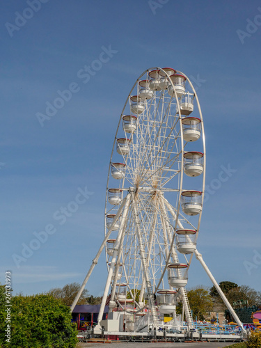 White ferris wheel against blue sky. Concept summer, fun fair, outdoors.