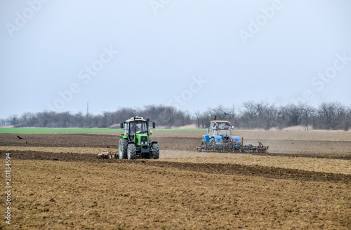 Lush and loosen the soil on the field before sowing. The tractor plows a field with a plow