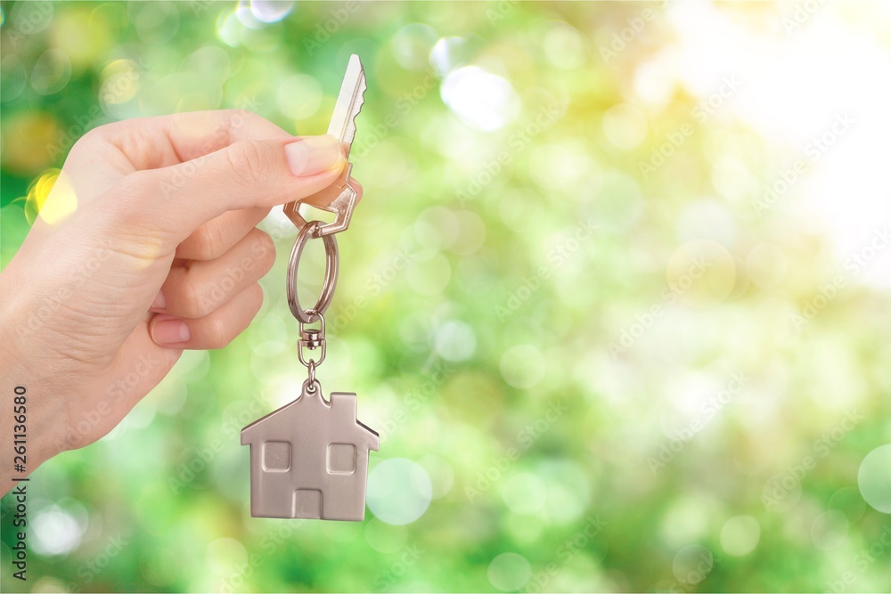House key in hand on blurred background