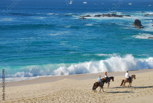 Tour with three horses on beach with a beautiful waves photo