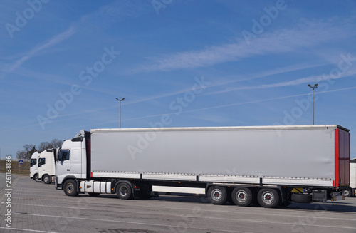 Trucks in the parking lot. A view of all cars from the side.