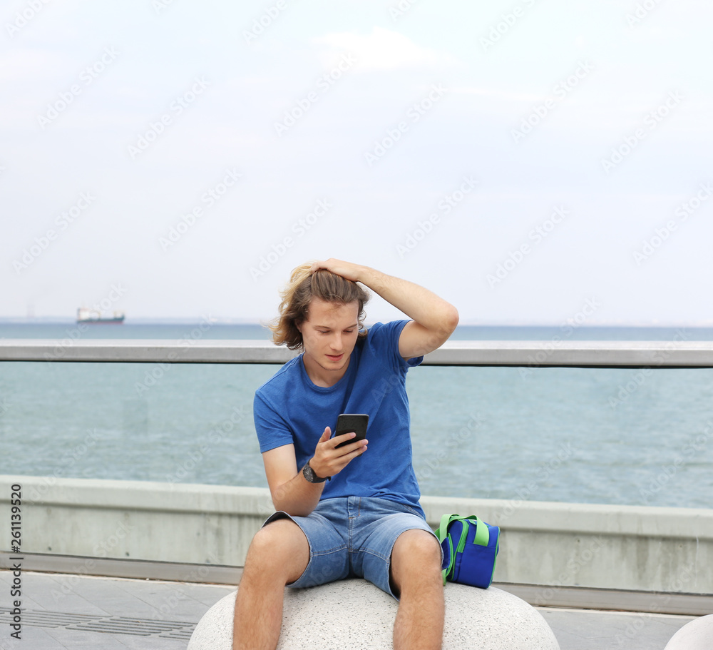 Teenage boy typing text message.Using smart phone.