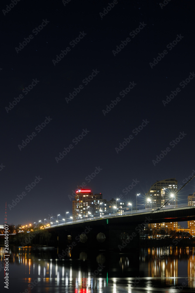 dark cityscape with illuminated buildings, lights, bridge and river dark cityscape with illuminated buildings, lights, bridge and river
