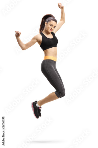 Happy young female in sportswear jumping