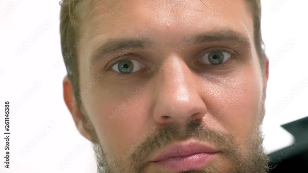 close-up, green-eyed handsome man perplexedly looks into the camera close-up, green-eyed handsome man perplexedly looks into the camera