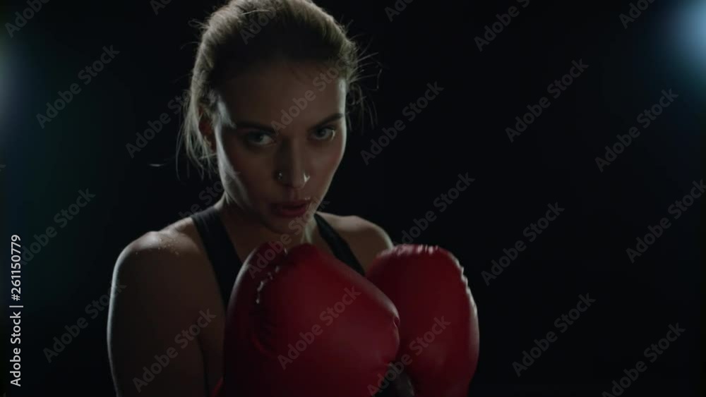 Woman boxer fighting with camera in slow motion. Woman fighter training Woman boxer fighting with camera in slow motion. Woman fighter training