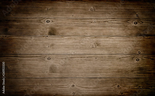 Warm brown wood surface with aged boards lined up. Wooden planks on a wall or floor with grain and texture. 