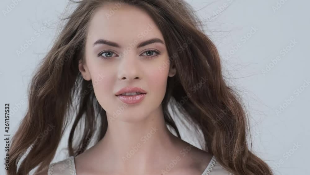 Beautiful woman with long brown hair. Attractive fashion model with flying curly hair. Beautiful brunette woman posing at studio. Slow motion. 4k footage.. Beautiful woman with long brown hair. Attractive fashion model with flying curly hair. Beautiful brunette woman posing at studio. Slow motion. 4k footage..